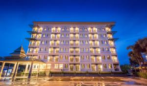 素叻Evergreen Suite Hotel的一座亮着灯的白色大楼