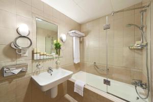 a bathroom with a sink and a shower and a tub at Al Manzel Hotel Apartments in Abu Dhabi