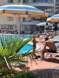 un gruppo di persone in una piscina con ombrelloni di Central Plaza Studio a Sunny Beach