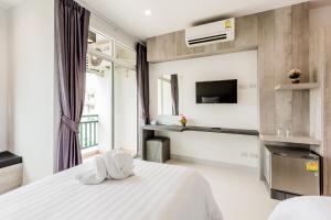 a hotel room with a large bed and a television at Evergreen Suite Hotel in Surat Thani
