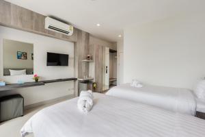 素叻Evergreen Suite Hotel的有两张床和一台电视的酒店房间