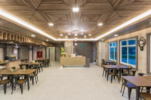 素叻Evergreen Suite Hotel的餐厅设有木制天花板和桌椅 更多35张照片