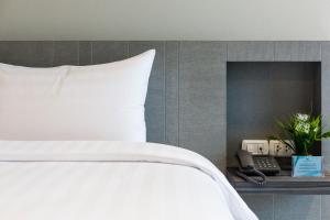 Postel nebo postele na pokoji v ubytování Evergreen Suite Hotel