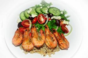 a plate of food with shrimp and vegetables on rice at Marine 5 Boutique Hotel in Gansbaai