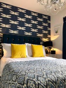 a bedroom with a large bed with yellow pillows at The Town House at Brecon in Brecon