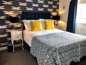 a bedroom with a large bed with yellow pillows at The Town House at Brecon in Brecon