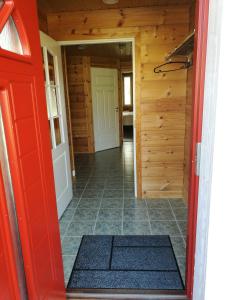 a hallway with a red door and a tile floor at Apartment A3 Talja in Rovaniemi