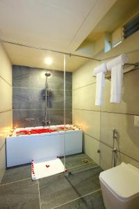 a bathroom with a shower with a tub and a toilet at Woodnote Thekkady in Thekkady
