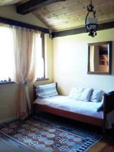 a bed sitting in a room with two windows at Il pettirosso di Giusvalla in Giusvalla
