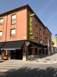 a brick building with a sign for a restaurant at Hostal Puerta La Villa in Tordesillas