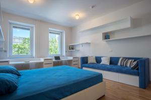 a bedroom with a blue bed and a couch at Luxury Central Apartment in Ljubljana