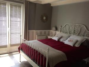 um quarto com uma cama grande com lençóis vermelhos e almofadas brancas em Tess Cottage em Brie-sous-Mortagne