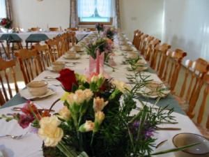 una mesa larga con flores encima en Gasthof Waldwirt, en Sankt Kanzian