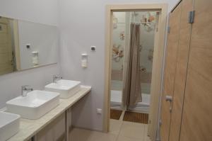 a white bathroom with two sinks and a shower at Hostel Energia in Kazan