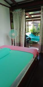 珍南海灘的住宿－T Star Cottage Langkawi，一间卧室配有一张床铺和一张桌子,并设有一个阳台