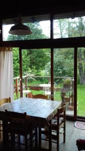 a dining room table with chairs and a view of a yard at Il pettirosso di Giusvalla in Giusvalla