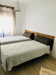 カンブリルスにあるEl Piset carrer Sant Jordiのベッド2台が隣同士に設置された部屋です。