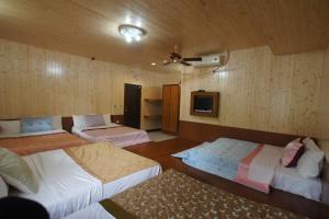 um quarto com quatro camas e uma televisão na parede em Music House Homestay em Nanzhuang