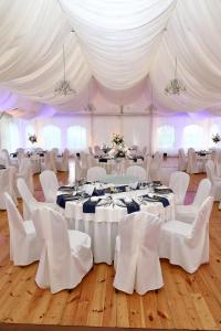a room with white tables and chairs and white tents at Hotel Dwór Sójki in Sójki