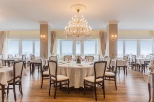 uma sala de jantar com mesas e cadeiras e um lustre em Luna Hotel Turismo em Abrantes