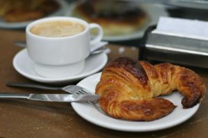 a plate with a croissant and a cup of coffee at Hotel Seminario Aeropuerto Bilbao in Derio