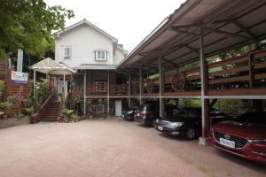 uma casa com carros estacionados num parque de estacionamento em Music House Homestay em Nanzhuang