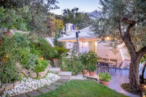 un jardín con una casa, una mesa y sillas en Villino La Piccolissima, en Massa Lubrense