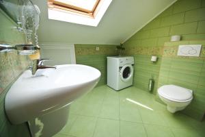 a bathroom with a sink and a washing machine at Sunrise Apartments in Cavtat