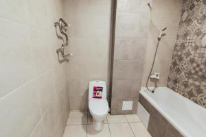 un baño con inodoro y bañera en Apartments Faraon, en Sumy 11 fotos más