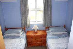 A bed or beds in a room at Giant's Causeway Holiday Cottages 