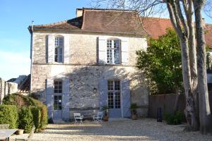 an old stone house with two chairs and a table at Le Petit Logis in Rouillac