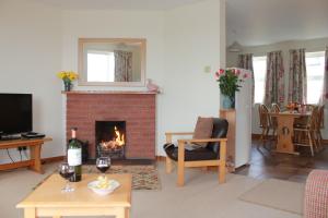 a living room with a fireplace and a table with wine glasses at Giant's Causeway Holiday Cottages in Bushmills +16 photos