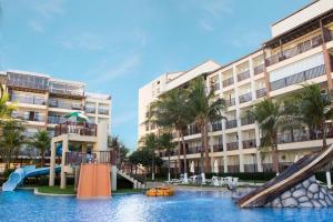a swimming pool with a slide in front of a building at Beach Living 1111 in Aquiraz