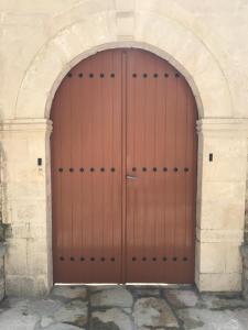 una grande porta in legno in un arco in pietra di Tourists Guest House a Gjirokastër