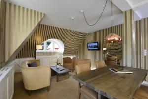 a living room with a dining room table and chairs at Waldhotel Stuttgart in Stuttgart