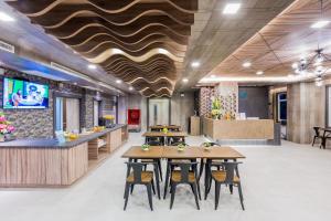素叻Evergreen Suite Hotel的一间带木桌椅的餐厅和一间酒吧