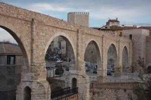 un viejo puente de piedra con arcos en una ciudad en Apartamento Torre del Salvador, en Teruel