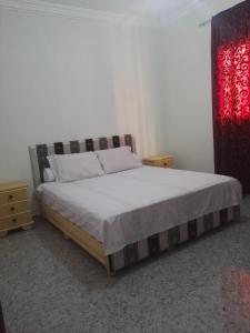 - une chambre avec un lit et un rideau rouge dans l'établissement Appartements Playa, à Saïdia