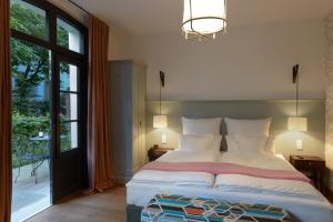ein Schlafzimmer mit einem großen Bett und einem Balkon in der Unterkunft Das kleine Grindel in Hamburg