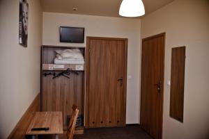 a room with two wooden doors and a table and a television at KOLUMNY 217- tanie noclegi pracownicze, parking bezpłatny in Łódź