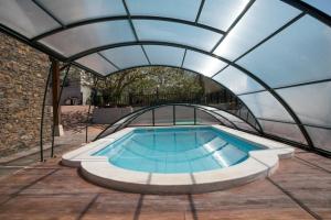 a swimming pool in a greenhouse with a roof at La Morada de Andoin in Andoín