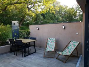 eine Terrasse mit einem Holztisch und Stühlen in der Unterkunft CasaCosy in Les Michels
