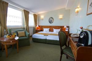 um quarto de hotel com uma cama, uma mesa e uma secretária em Hotel am Luisenplatz em Potsdam