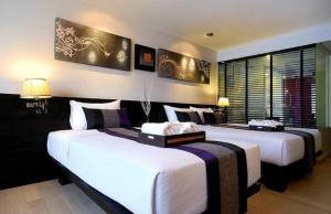 two beds in a hotel room with white and purple at Nouvo City Hotel in Bangkok +113 photos