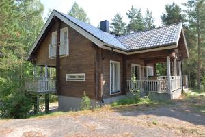 a log house with a porch and a balcony at Mäntykallio in Loviisa