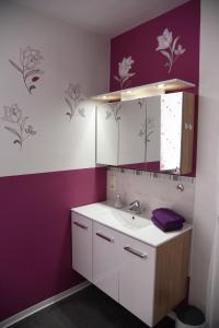 een badkamer met een wastafel en een paarse muur bij Pension Heib in Cochem