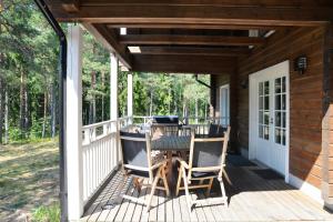 a porch with a table and chairs on it at Mäntykallio in Loviisa