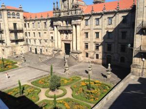 a large building with a garden in front of it at Pensión Acibeche in Santiago de Compostela