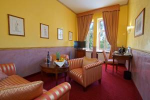 a living room with yellow walls and a table and chairs at Hotel am Luisenplatz in Potsdam