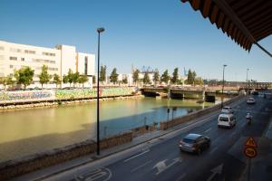 a street with cars driving down a road next to a river at Soho River in Málaga